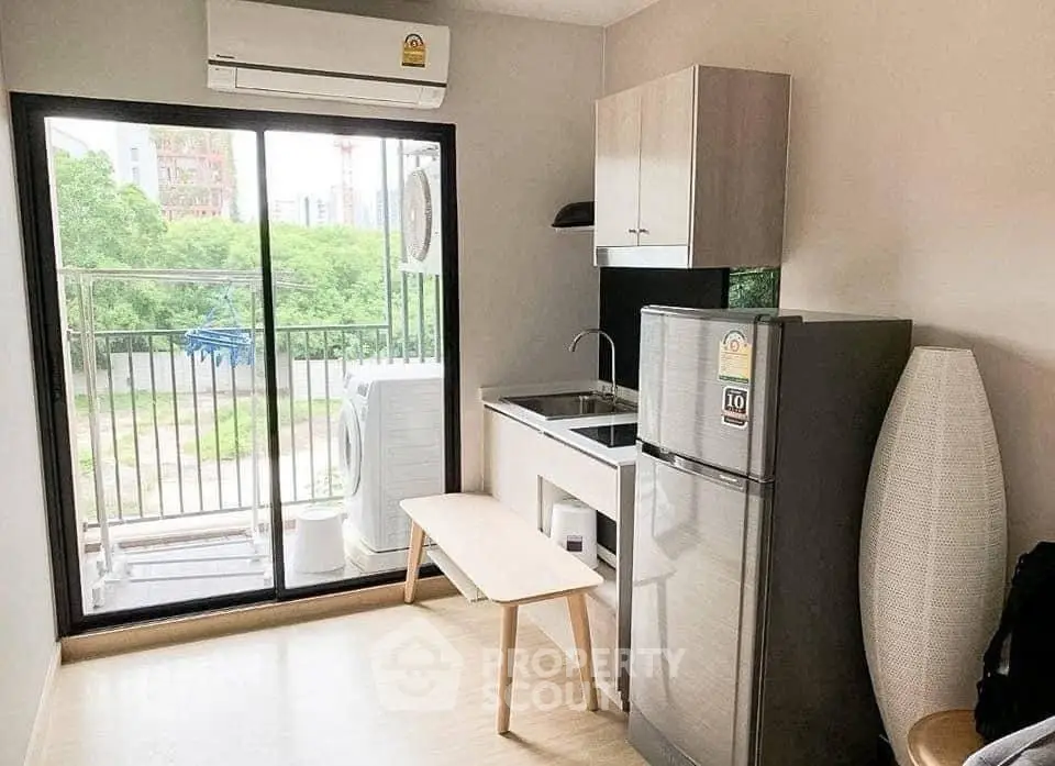 Modern compact kitchen with balcony view in urban apartment