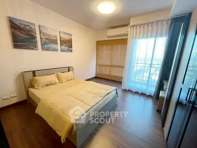 Spacious bedroom with modern decor and large window offering natural light.