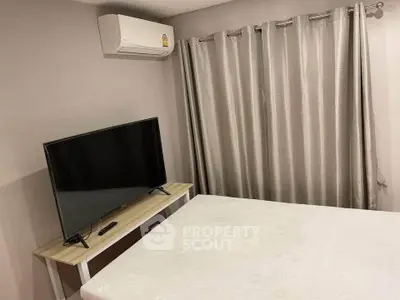 Cozy bedroom with air conditioning and modern TV setup, perfect for relaxation.