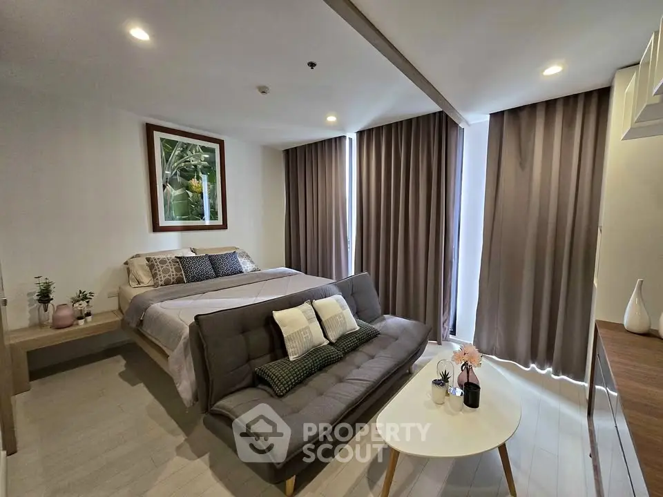 Modern bedroom with stylish decor and cozy seating area, perfect for relaxation and comfort.