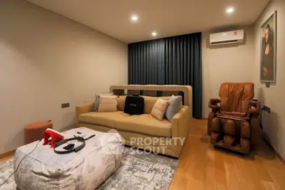 Cozy living room with modern sofa, massage chair, and gaming setup in stylish apartment.