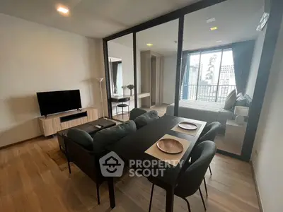 Modern open-plan living room with dining area and city view in a stylish apartment.