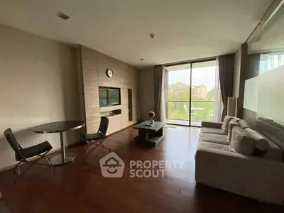 Spacious living room with modern furniture and large window offering a serene view.