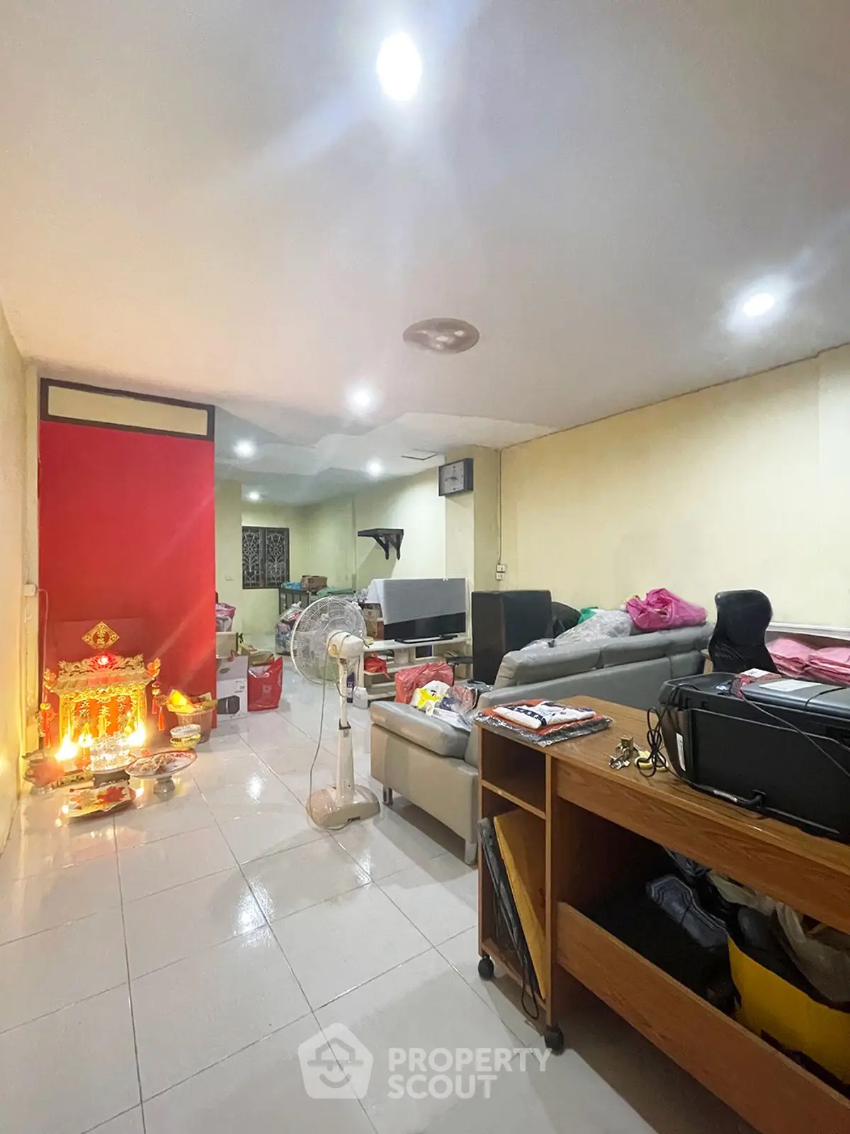 Spacious living room with modern furniture and vibrant red accent wall, ideal for family gatherings.