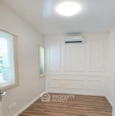 Bright and airy room with elegant paneling and modern air conditioning unit, perfect for a cozy living space.