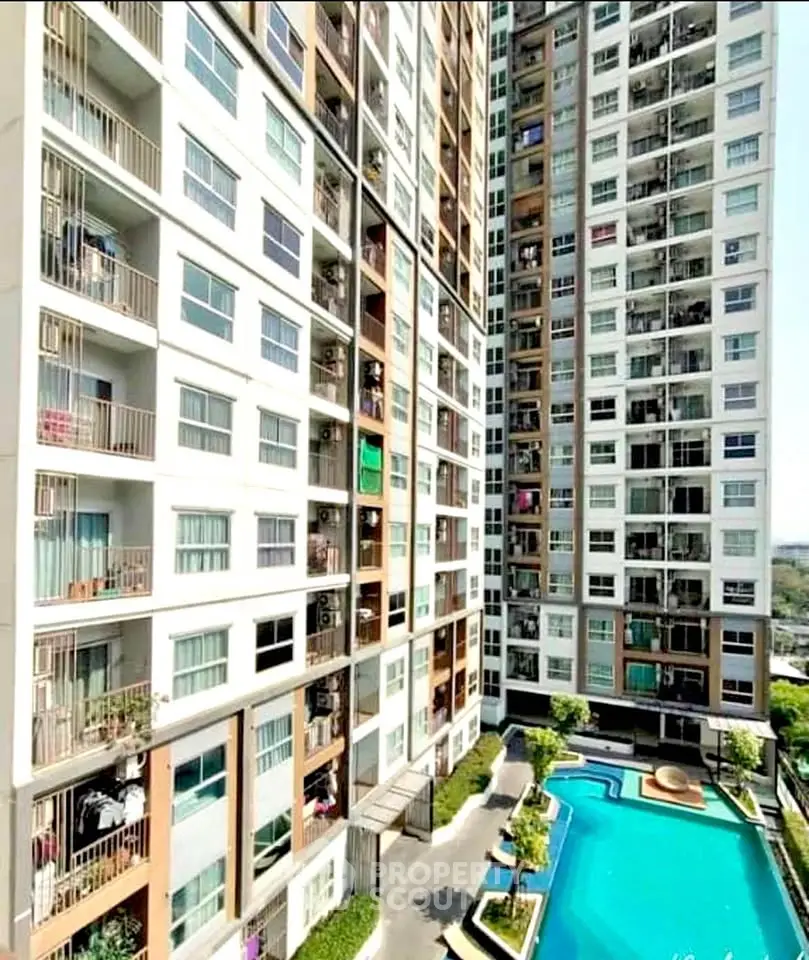 High-rise residential building with modern pool and lush garden view.