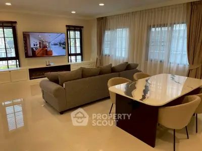 Spacious living room with modern decor and large TV, perfect for relaxation and entertainment.