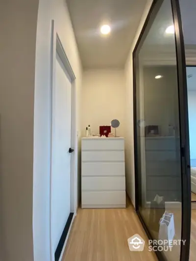 Modern hallway with sleek storage and sliding glass door in contemporary home.