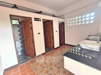 Spacious public restroom with modern sinks and multiple stalls.