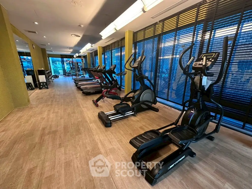 Modern gym with state-of-the-art fitness equipment and large windows for natural light.