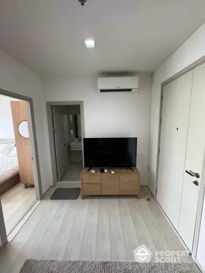 Modern apartment interior with TV and air conditioning, showcasing minimalist design and cozy atmosphere.