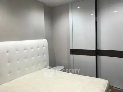Modern bedroom with sleek white wardrobe and upholstered headboard