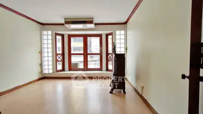 Spacious living room with large windows and wooden flooring