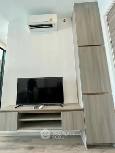 Modern living room with sleek TV stand and air conditioning unit.