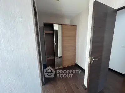 Modern bedroom with sleek wooden flooring and built-in wardrobe