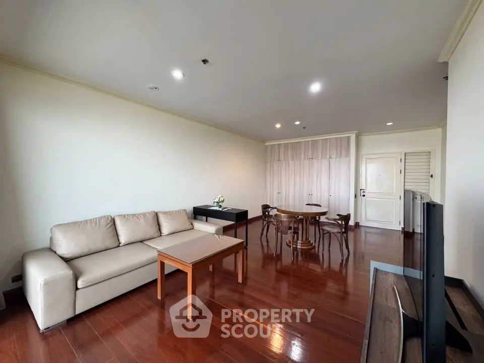 Spacious living room with elegant wooden flooring and modern furniture in a stylish apartment.