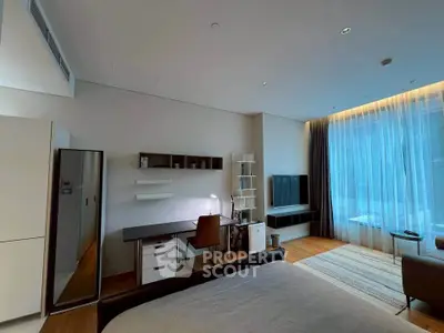 Modern bedroom with study area, large window, and stylish decor