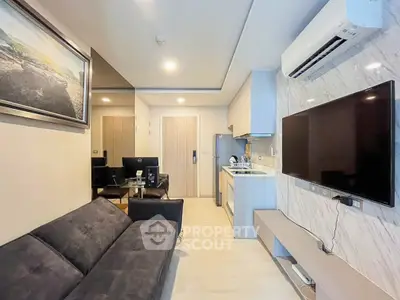 Modern living room with sleek kitchen and large TV, perfect for urban living.