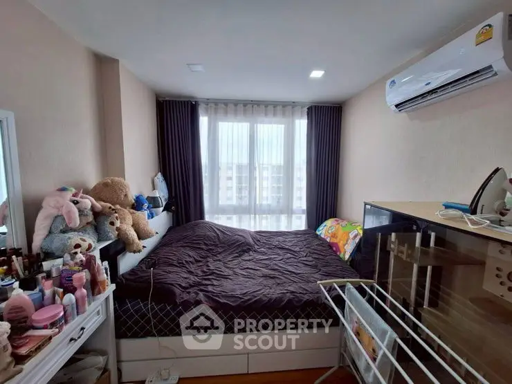 Cozy bedroom with air conditioning and ample natural light from large window.