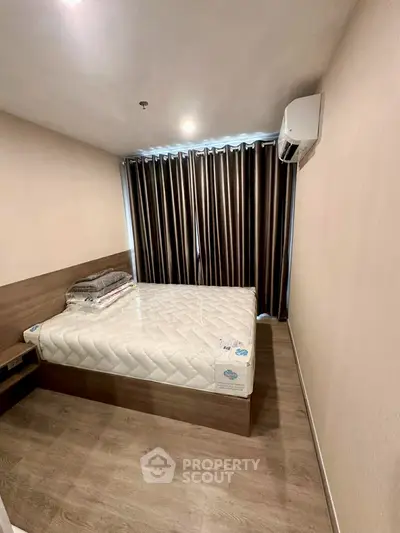 Cozy bedroom with modern design, featuring a comfortable bed and air conditioning, perfect for restful nights.