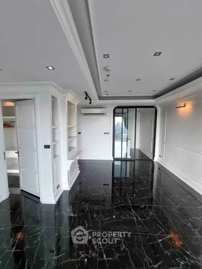 Luxurious modern living room with glossy black marble flooring and elegant white walls.