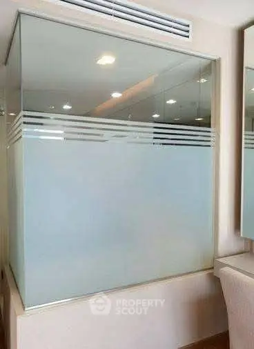 Modern bathroom with frosted glass shower enclosure and sleek design.