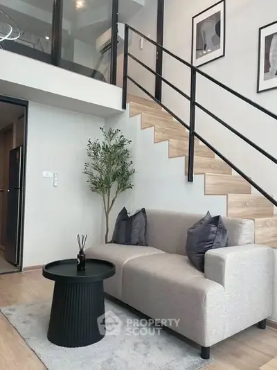 Modern living room with stylish staircase and cozy seating area in a contemporary apartment.
