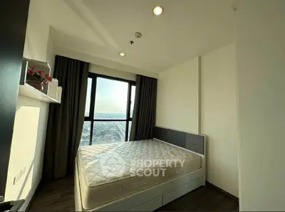 Modern bedroom with large window offering stunning city view