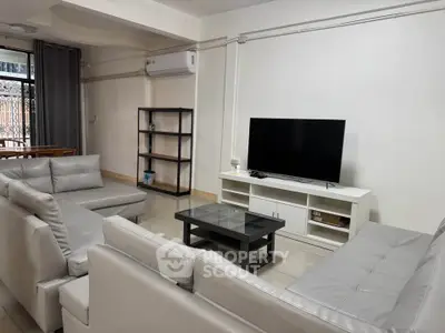 Spacious living room with modern furniture and large TV, perfect for relaxation.