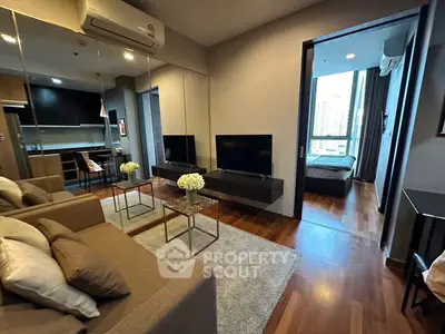 Modern living room with sleek design, cozy seating, and open view to bedroom, perfect for urban living.