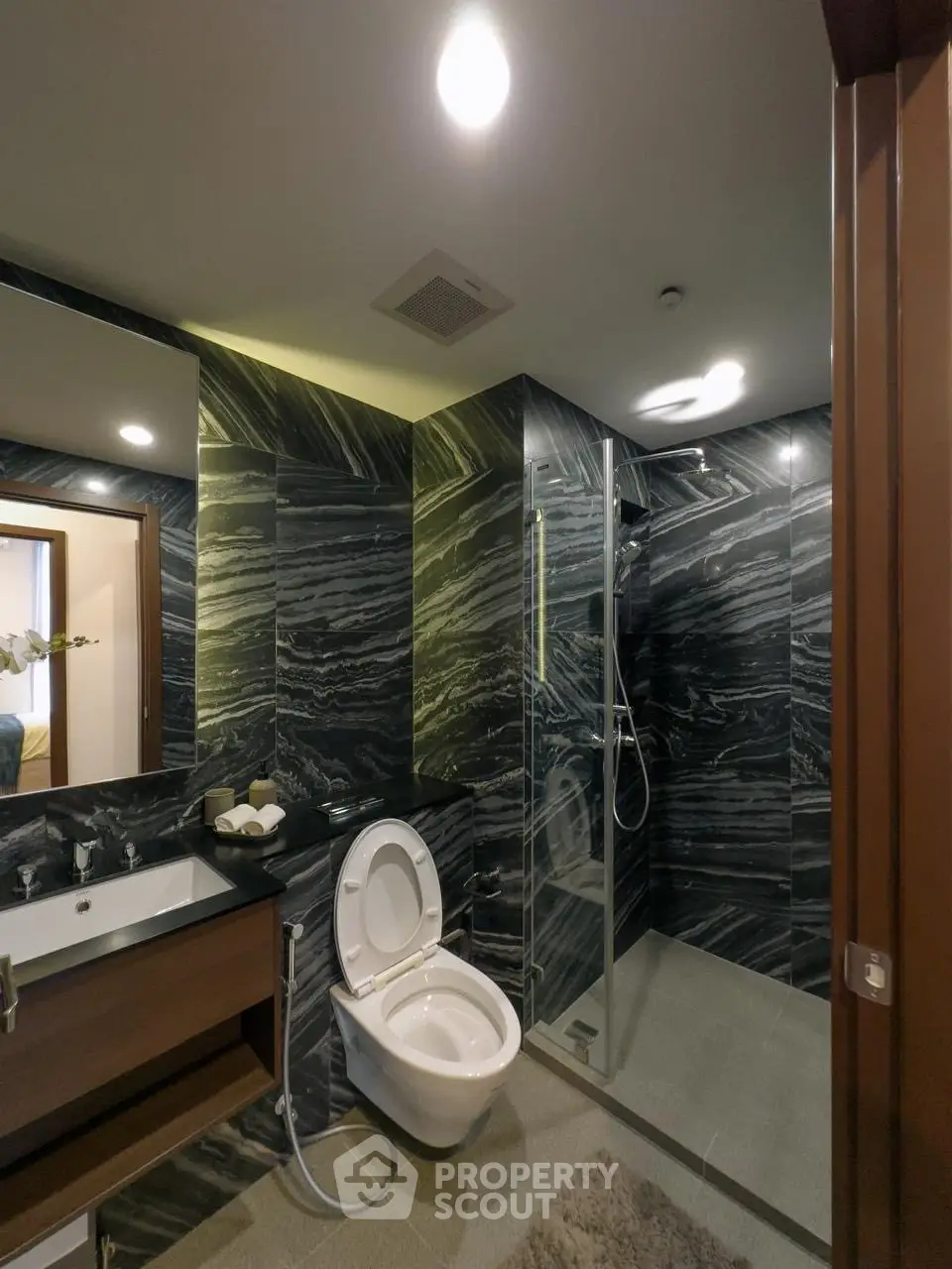 Luxurious modern bathroom with sleek black marble walls and elegant fixtures.
