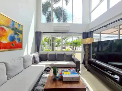 Spacious living room with large windows and modern decor, perfect for relaxation.