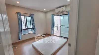 Spacious bedroom with balcony access and air conditioning in modern home