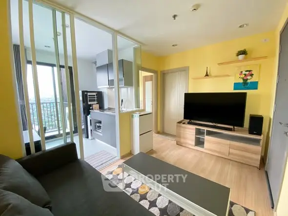 Modern living room with open kitchen and balcony view in bright apartment.