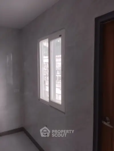 Minimalist bathroom with window and tiled walls, ideal for modern living.