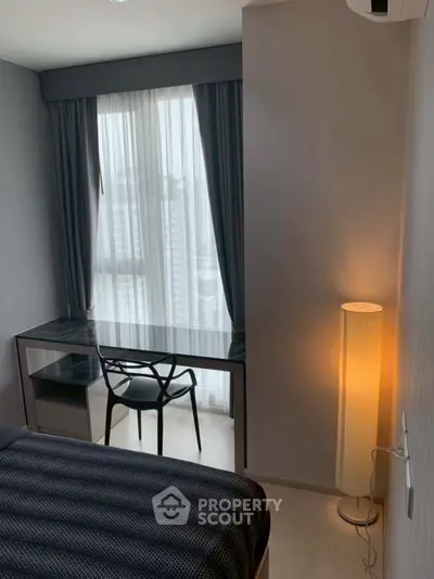 Modern bedroom with sleek desk and chair by large window, ambient lighting.