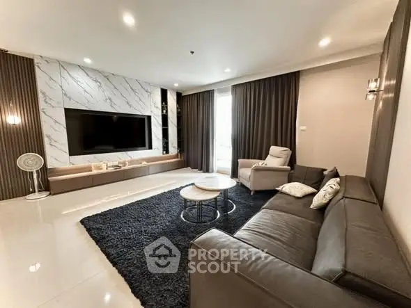 Luxurious living room with modern decor, large TV, and elegant marble accents.