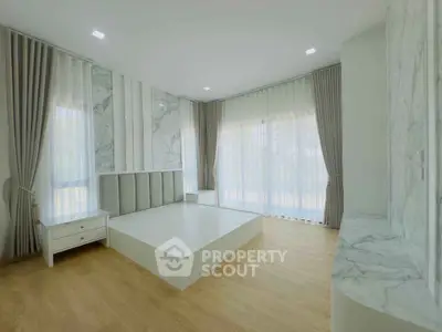 Spacious modern bedroom with elegant marble accents and large windows
