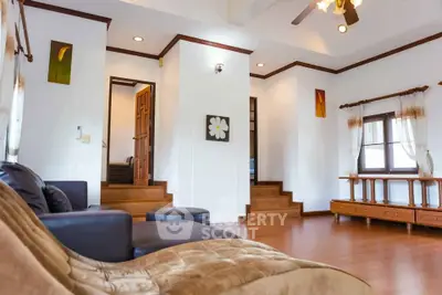 Spacious living room with elegant wooden flooring and cozy seating area.