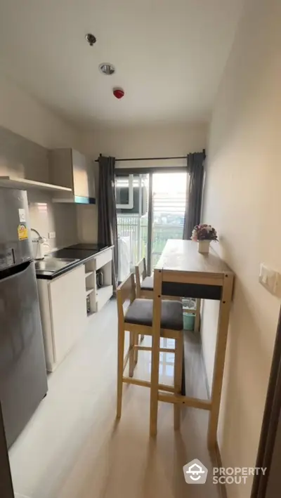 Modern compact kitchen with dining area and balcony view