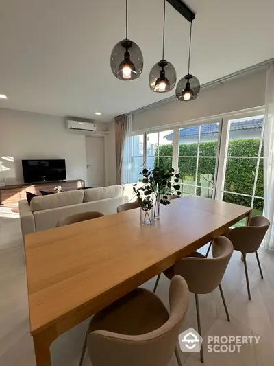 Modern living room with large windows and stylish dining area