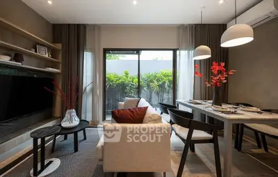 Modern living room with stylish decor and garden view, featuring elegant dining area and cozy seating.