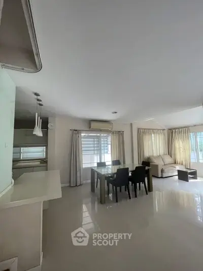 Spacious living room with modern dining area and natural light
