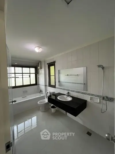 Spacious bathroom with modern fixtures and large window for natural light.