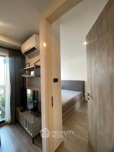 Modern bedroom with balcony view, featuring sleek furniture and natural light, perfect for urban living.