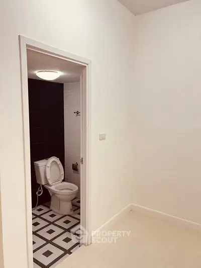 Minimalist bathroom with geometric floor tiles and modern fixtures.