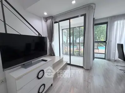 Modern living room with TV and pool view through large windows