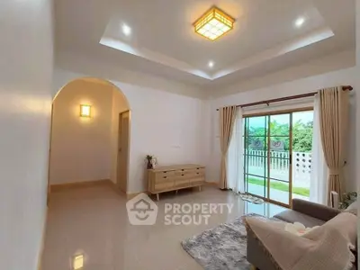 Spacious living room with modern lighting and large sliding doors to balcony