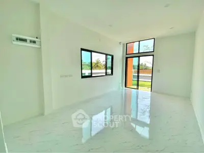 Spacious modern living room with large windows and glossy tiled floor