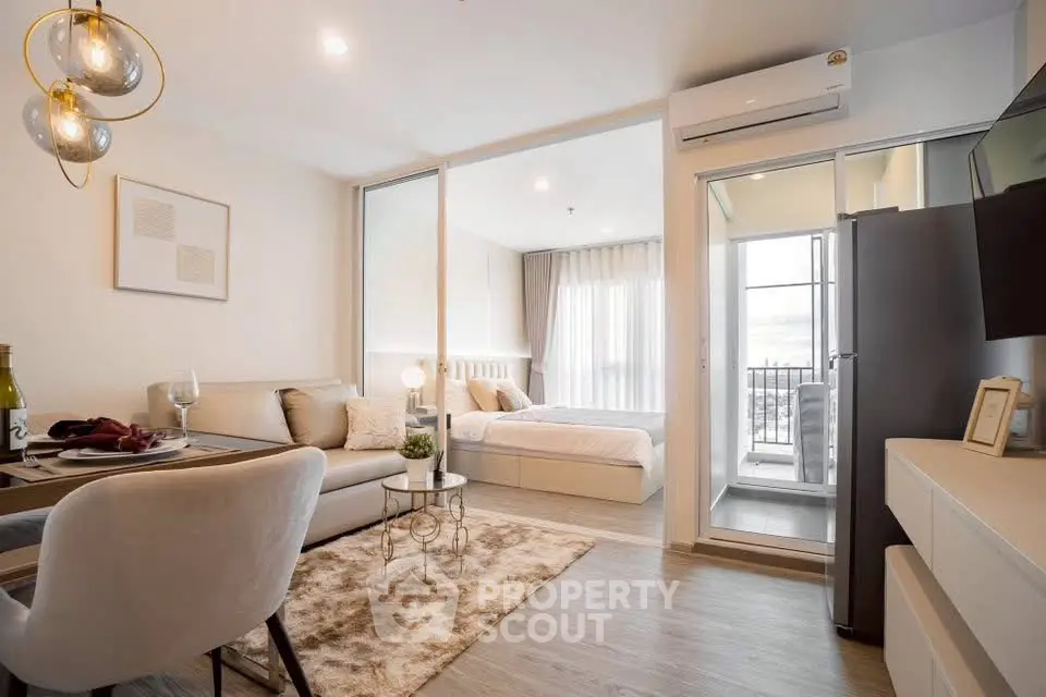 Modern open-plan living room with cozy dining area and elegant bedroom view.